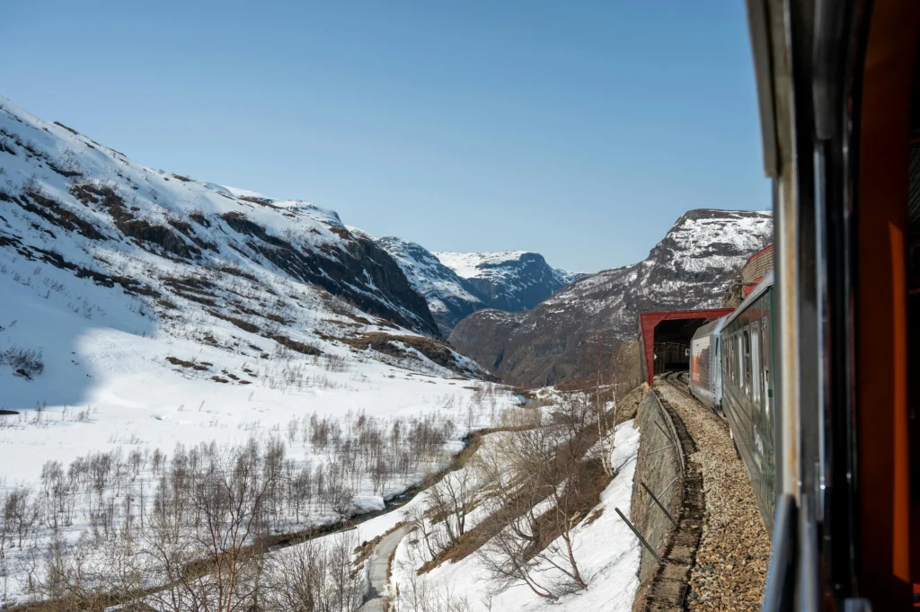 Best European train Flåm Railway passing waterfalls and steep fjord cliffs